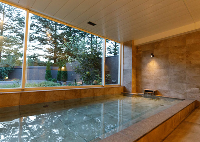 Enjoy the open-air bath in the morning, bathed in sunlight filtering through the trees.